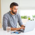 Man smiling working using computer laptop